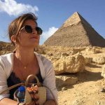 A client looking intently at one of the Giza Pyramids, with a slight smile, suggesting the fulfillment of a travel dream