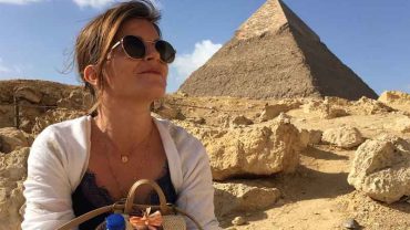 A client looking intently at one of the Giza Pyramids, with a slight smile, suggesting the fulfillment of a travel dream