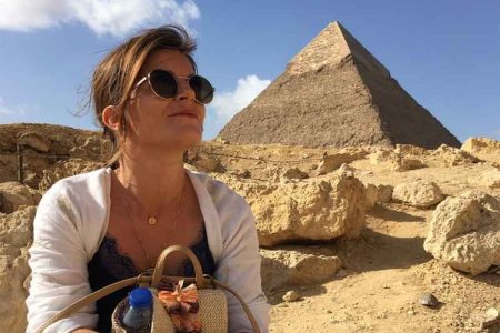 A client looking intently at one of the Giza Pyramids, with a slight smile, suggesting the fulfillment of a travel dream