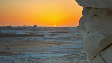 The unique chalk-white rock formations of the White Desert bathed in the soft, warm light of a desert sunrise near Bahariya Oasis